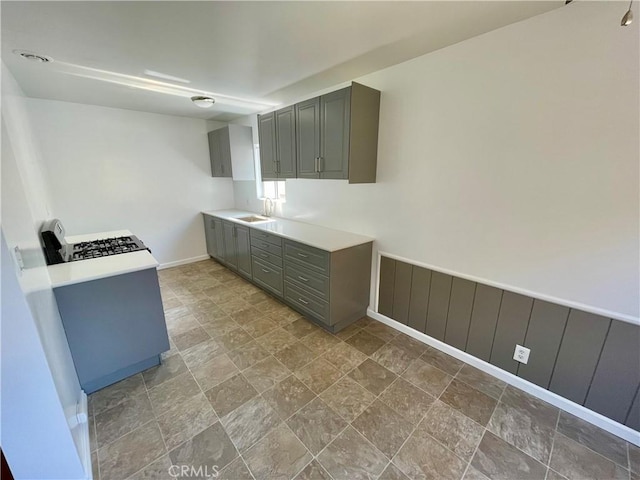 341 N Isabel St, Glendale, CA 91206 - kitchen with stone finish floor, gray cabinets, a sink, baseboards, and gas range