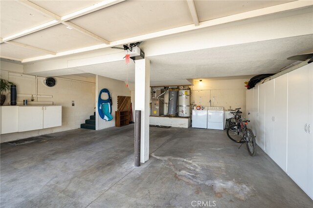 46375 Ryway Pl Unit 2, Palm Desert, CA 92260 - garage featuring washer and clothes dryer, strapped water heater, a garage door opener, and heating unit