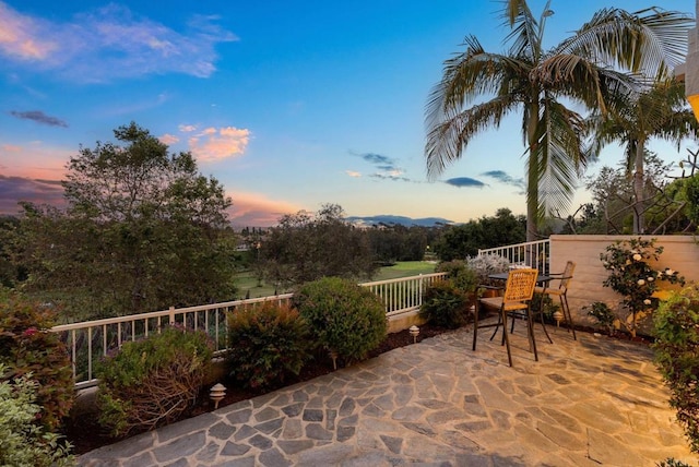 patio terrace at dusk featuring fence