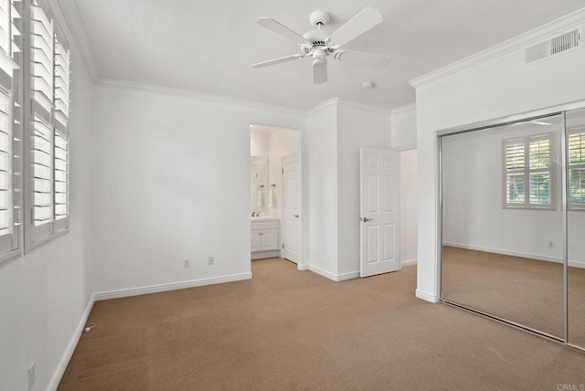 unfurnished bedroom with carpet, crown molding, a closet, baseboards, and a ceiling fan