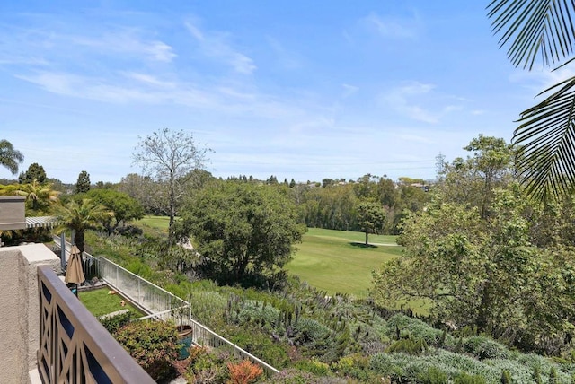 view of yard with fence, view of golf course, and view of scattered trees