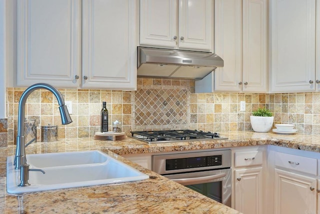 kitchen with a sink, stainless steel appliances, under cabinet range hood, and white cabinets