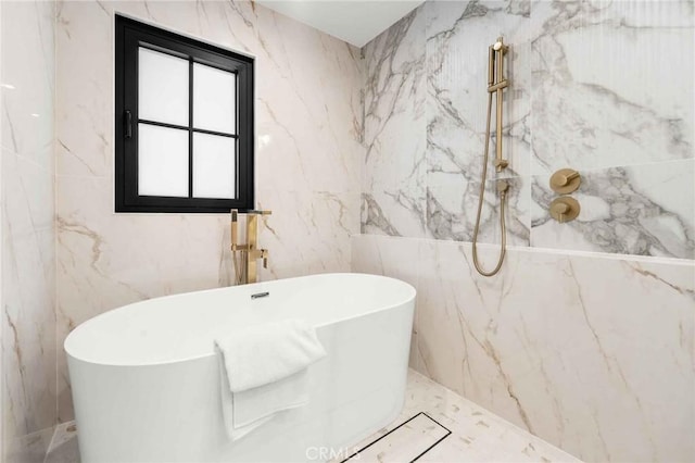 bathroom featuring a freestanding tub, tile walls, and a marble finish shower