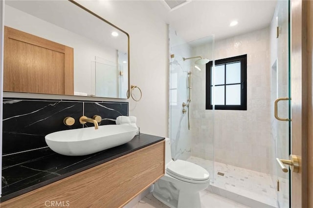 bathroom with recessed lighting, vanity, a stall shower, and toilet