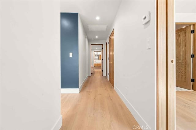 corridor featuring recessed lighting, baseboards, and light wood finished floors