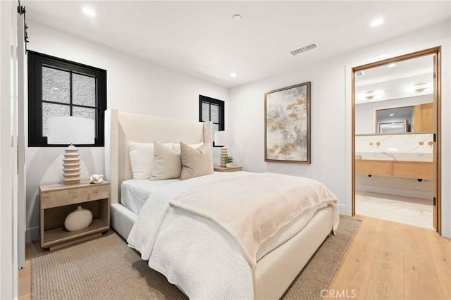 bedroom with visible vents, recessed lighting, light wood-style flooring, and connected bathroom