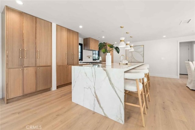 kitchen with a spacious island, recessed lighting, modern cabinets, and light wood-type flooring