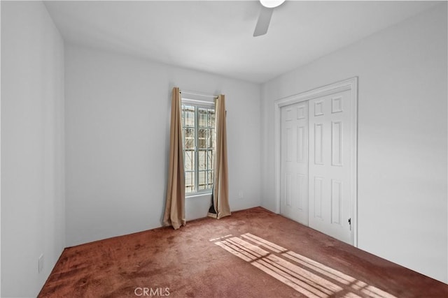 unfurnished bedroom featuring a ceiling fan, a closet, and carpet flooring