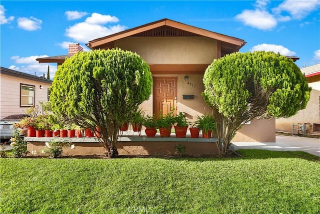 view of front of house with a front lawn and stucco siding