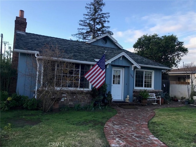 17838-17840 Los Alimos St, Granada Hills, CA 91344 - view of front of house featuring a front yard, a chimney, and roof with shingles