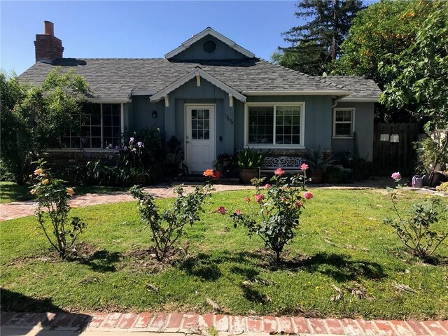 17838-17840 Los Alimos St, Granada Hills, CA 91344 - single story home featuring a shingled roof, a chimney, a front yard, and board and batten siding