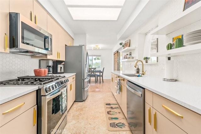 kitchen featuring stainless steel appliances, open shelves, light countertops, a sink, and tasteful backsplash