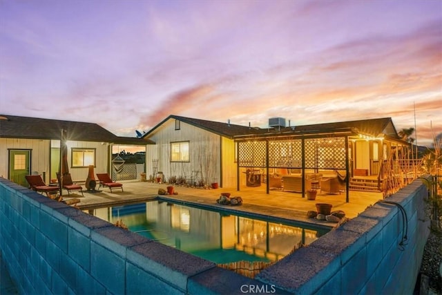 pool at dusk featuring an outdoor hangout area, central air condition unit, a patio, and an outdoor pool