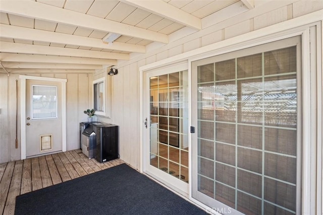 unfurnished sunroom with beam ceiling