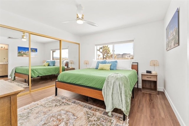 bedroom with wood finished floors, a closet, baseboards, and ceiling fan