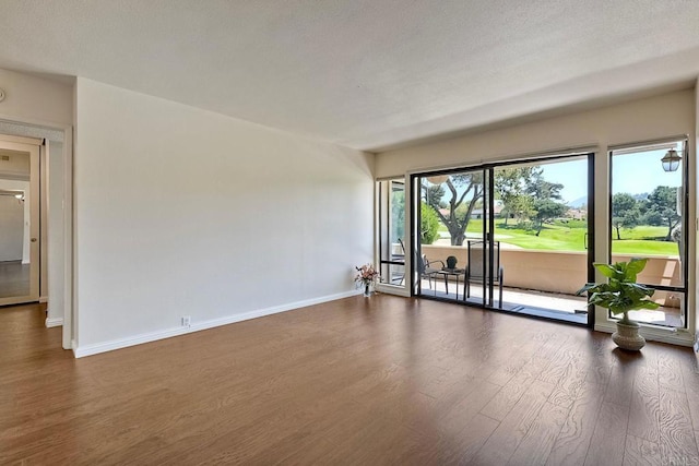 unfurnished room featuring dark wood-style flooring and baseboards