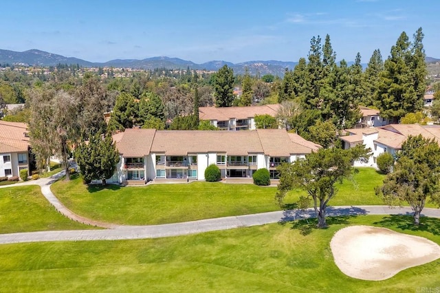 view of front of home with a mountain view and a front lawn