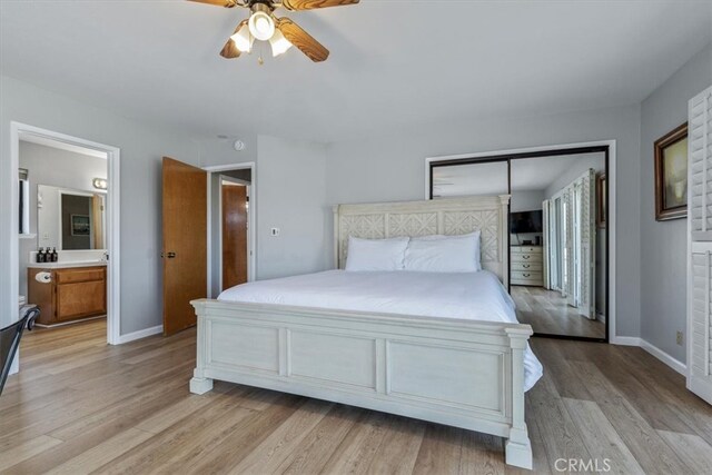 bedroom featuring baseboards, a ceiling fan, ensuite bathroom, and light wood-type flooring