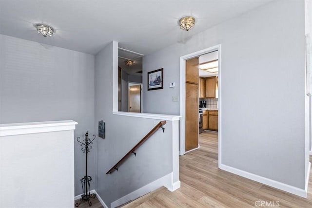 staircase with attic access, baseboards, and wood finished floors