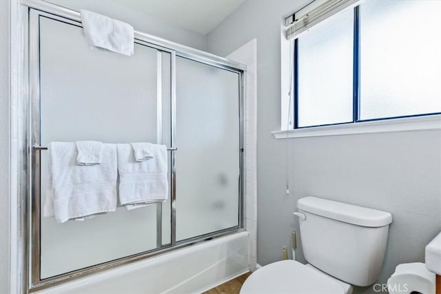 full bathroom with shower / bath combination with glass door and toilet