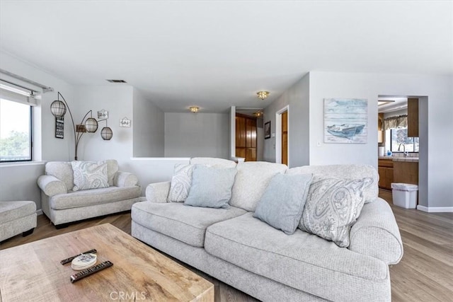 living room featuring baseboards, wood finished floors, and visible vents