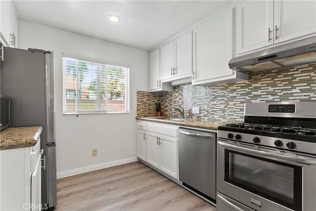 5593 Pioneer Blvd Unit 18, Whittier, CA 90601 - kitchen featuring appliances with stainless steel finishes, under cabinet range hood, a sink, backsplash, and light wood-style floors