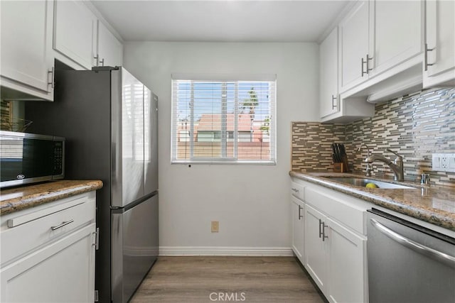5593 Pioneer Blvd Unit 18, Whittier, CA 90601 - kitchen with stainless steel appliances, a sink, tasteful backsplash, wood finished floors, and baseboards