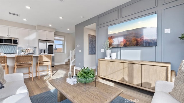 302 Fawn St, Rancho Mission Viejo, CA 92694 - living room featuring recessed lighting, stairway, visible vents, light wood-style floors, and baseboards