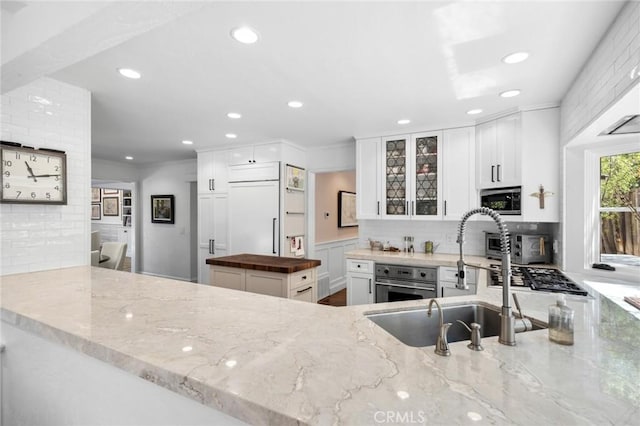 1981 Port Dunleigh Cir, Newport Beach, CA 92660 - kitchen with appliances with stainless steel finishes, tasteful backsplash, a sink, and white cabinetry