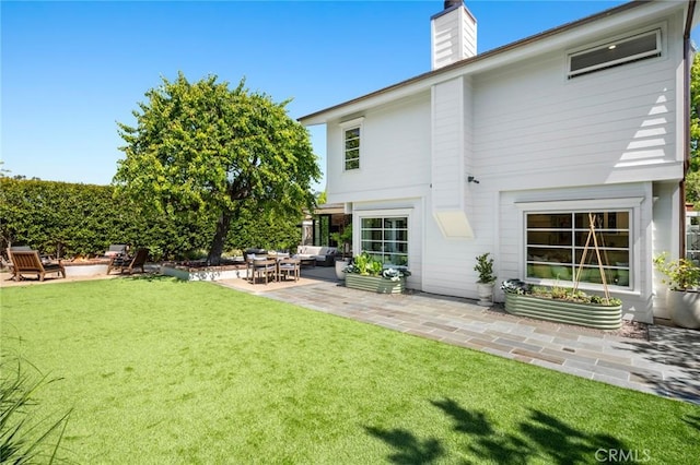1981 Port Dunleigh Cir, Newport Beach, CA 92660 - rear view of house with a chimney, a yard, an outdoor living space with a fire pit, and a patio area