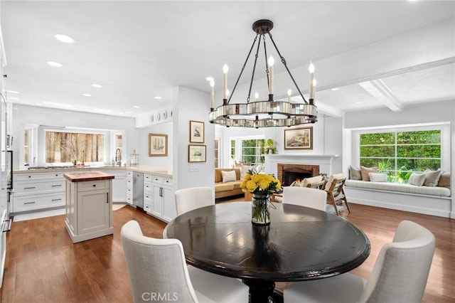 1981 Port Dunleigh Cir, Newport Beach, CA 92660 - dining room featuring dark wood-style floors, beam ceiling, recessed lighting, a chandelier, and a fireplace