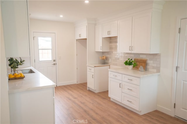 6022 Camerino, Lakewood, CA 90713 - kitchen with light wood-style flooring, tasteful backsplash, recessed lighting, and white cabinetry