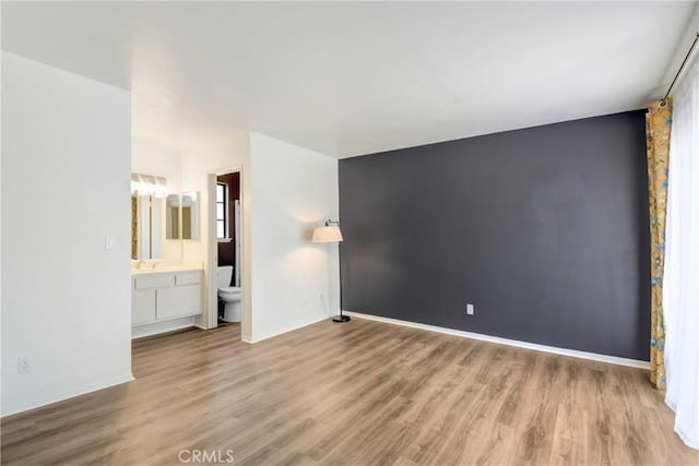 28 Dearborn Cir, Redlands, CA 92374 - unfurnished bedroom with wood finished floors, baseboards, connected bathroom, and a sink
