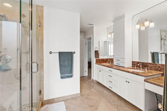 bathroom with a shower stall, visible vents, tile patterned floors, and a sink