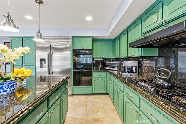 kitchen with dark stone counters, tasteful backsplash, black appliances, pendant lighting, and under cabinet range hood