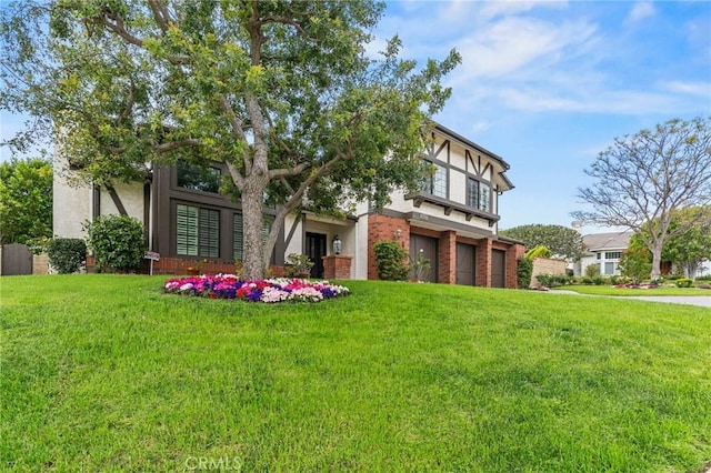 back of property with a garage, a yard, brick siding, and stucco siding