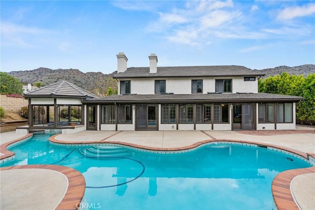 view of swimming pool with a gazebo, a mountain view, a fenced in pool, a patio, and a sunroom