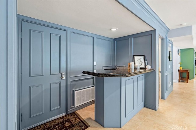 interior space featuring light tile patterned flooring, a decorative wall, and visible vents