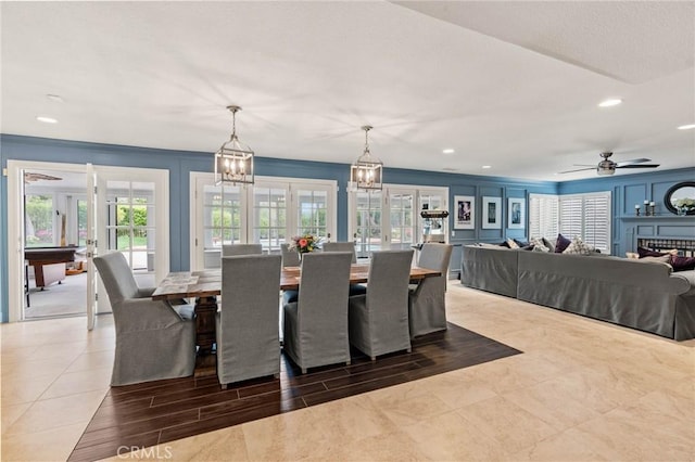 dining area featuring french doors, recessed lighting, ceiling fan with notable chandelier, a fireplace, and ornamental molding