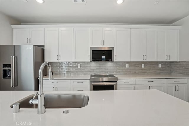 2070 Zest St, Redlands, CA 92374 - kitchen with stainless steel appliances, a sink, white cabinetry, light countertops, and recessed lighting