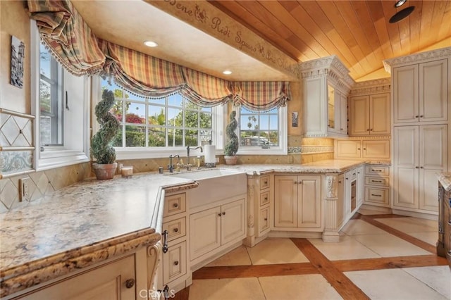 kitchen featuring light stone counters, a sink, wood ceiling, cream cabinets, and recessed lighting