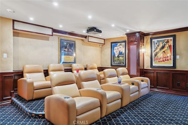 home theater with wainscoting, a decorative wall, ornamental molding, and carpet flooring