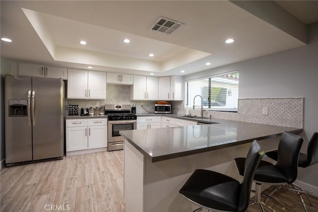 73640 Joshua Tree St, Palm Desert, CA 92260 - kitchen with a sink, a raised ceiling, a peninsula, appliances with stainless steel finishes, and visible vents
