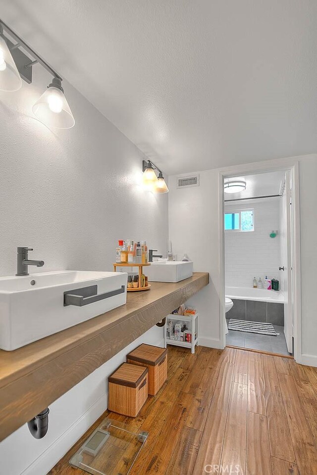 686 E Workman St, Covina, CA 91723 - full bath with a sink, hardwood / wood-style flooring, a bath, and toilet