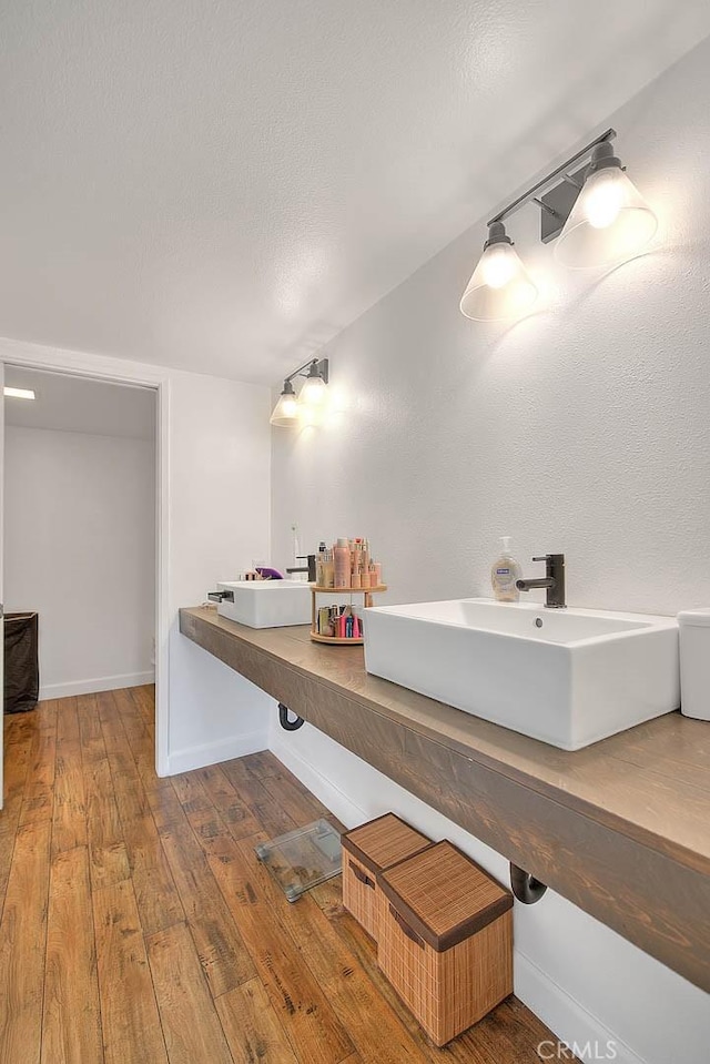 686 E Workman St, Covina, CA 91723 - bathroom with hardwood / wood-style flooring, a sink, a textured ceiling, and baseboards