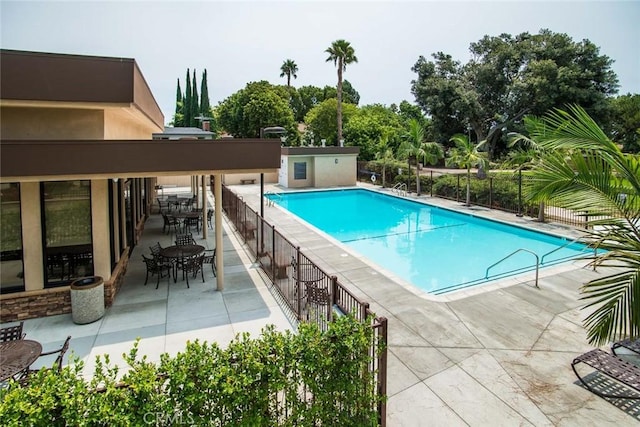 community pool with a patio and fence