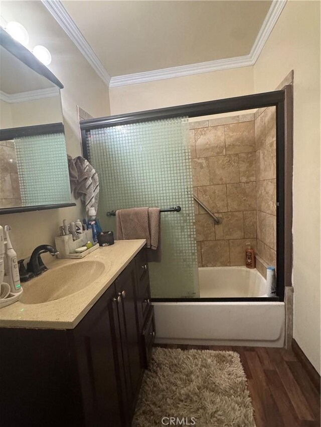 full bath featuring crown molding, enclosed tub / shower combo, wood finished floors, and vanity