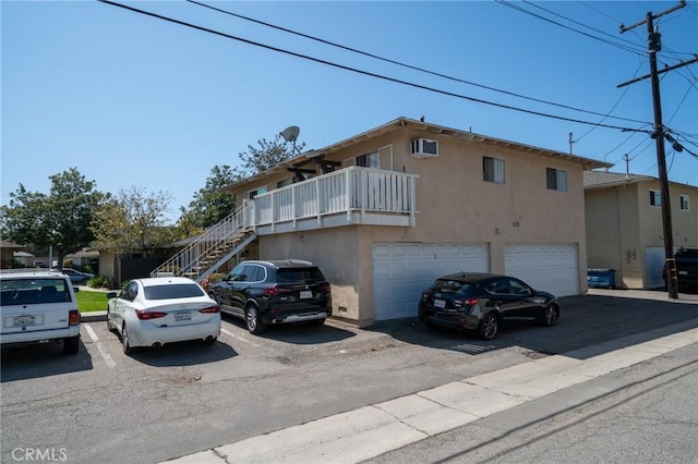 view of front facade with a garage, stairs, and stucco siding