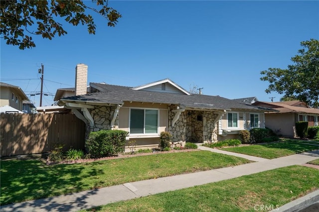 single story home with fence, a front lawn, a chimney, and stone siding
