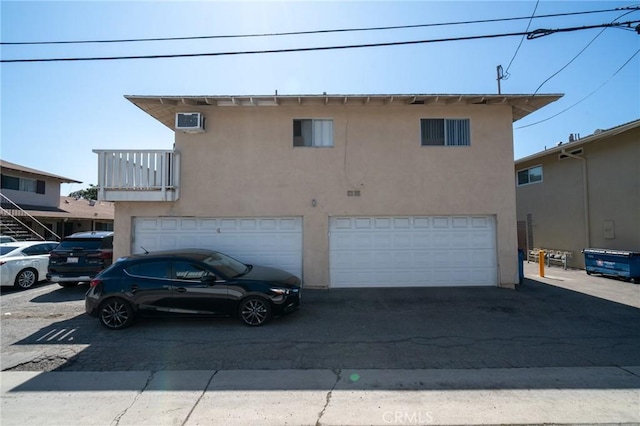 front of property with an attached garage, driveway, and stucco siding